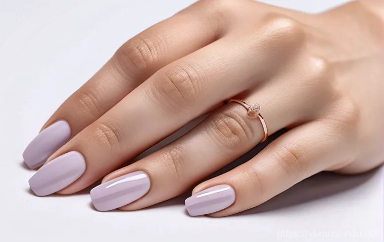 기타 손톱 관리 - A close-up of a Vietnamese woman's elegant hands, showcasing perfectly manicured, short, almond-shap...